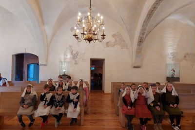 bērni sēž uz koka soliem